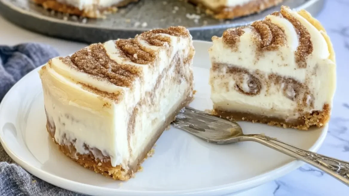 Layered cinnamon roll cheesecake on a plate with cream cheese frosting and caramel topping